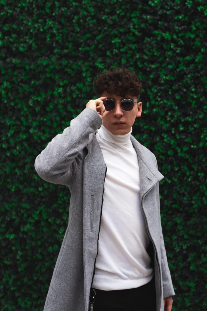 Young Latino man with curly hair and sunglasses outdoors